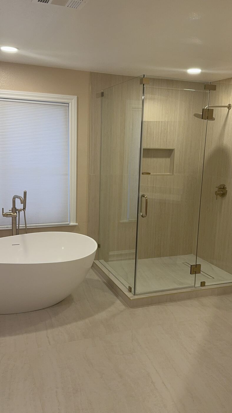 Primary bathroom remodel with freestanding tub and glass shower enclosure