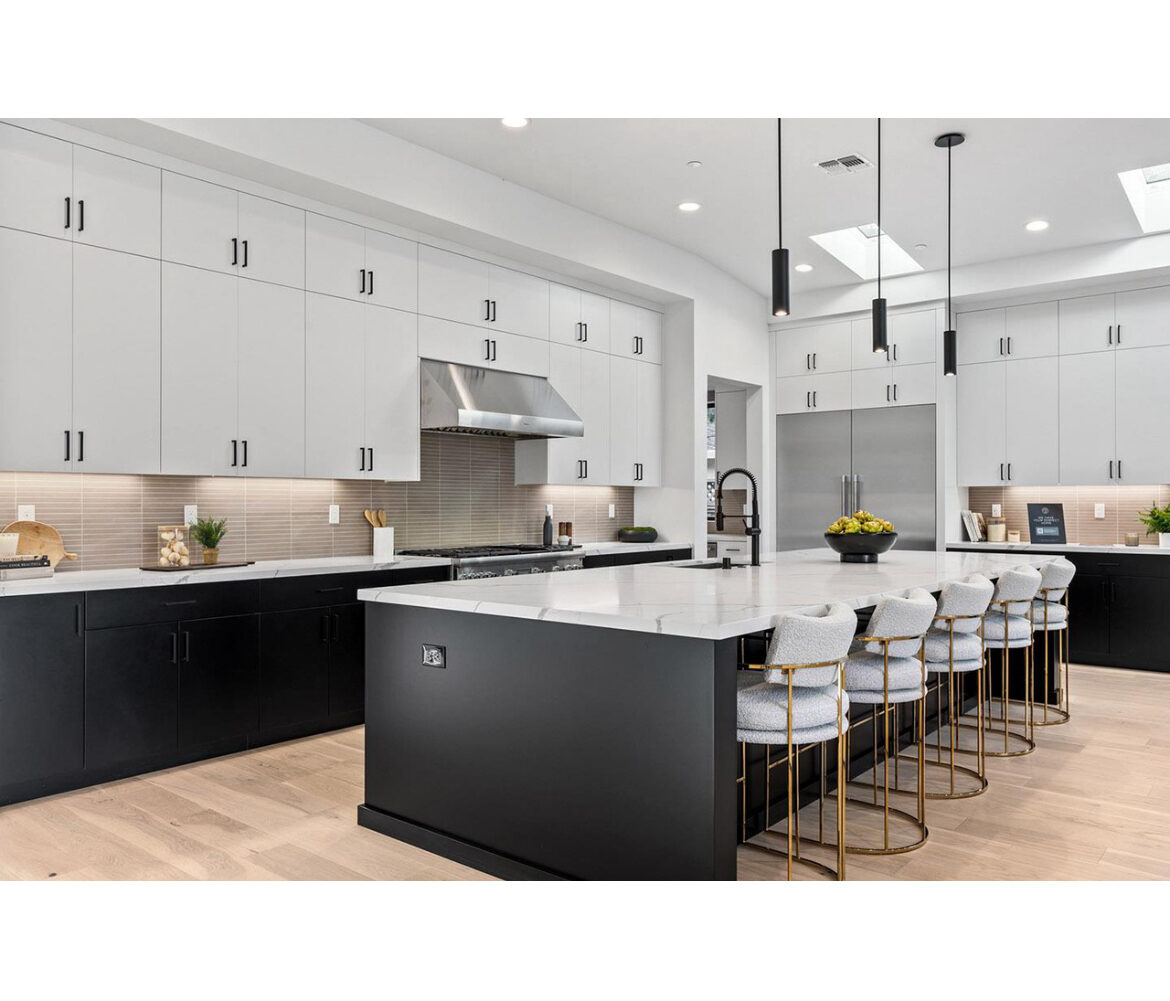 Luxury Las Vegas kitchen remodel with black cabinetry, white quartz island and gold barstools